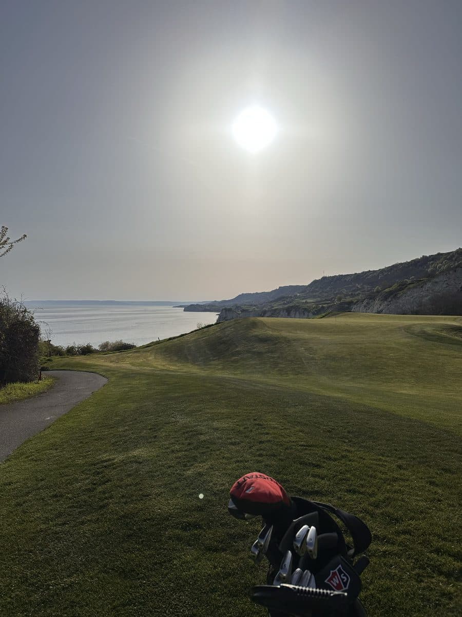 Golf bag on a slope above a lake in the sun